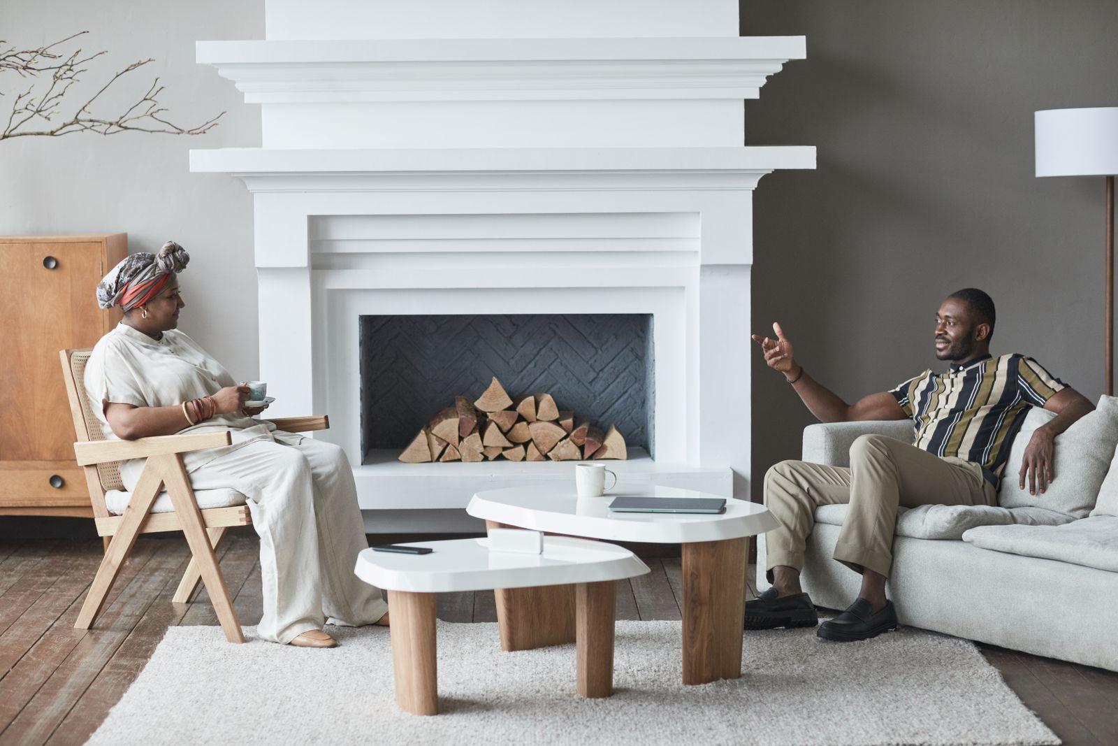 Two people talking over coffee in a living room at home